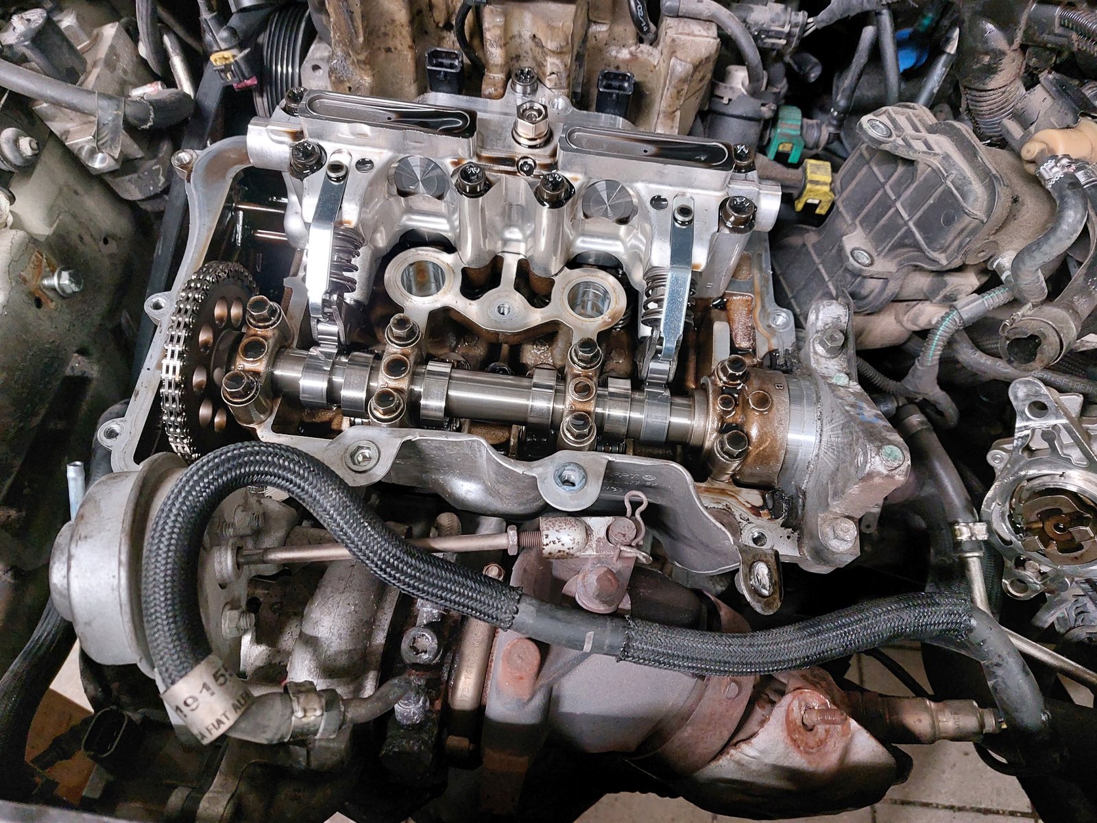 The hardware in situ: camshafts and timing chain in an automotive cylinder head. The chain fixes the cams' speed to the crank at a strict two-to-one. What a phaser changes is not that ratio but the angle at which the cam sits relative to the crank.