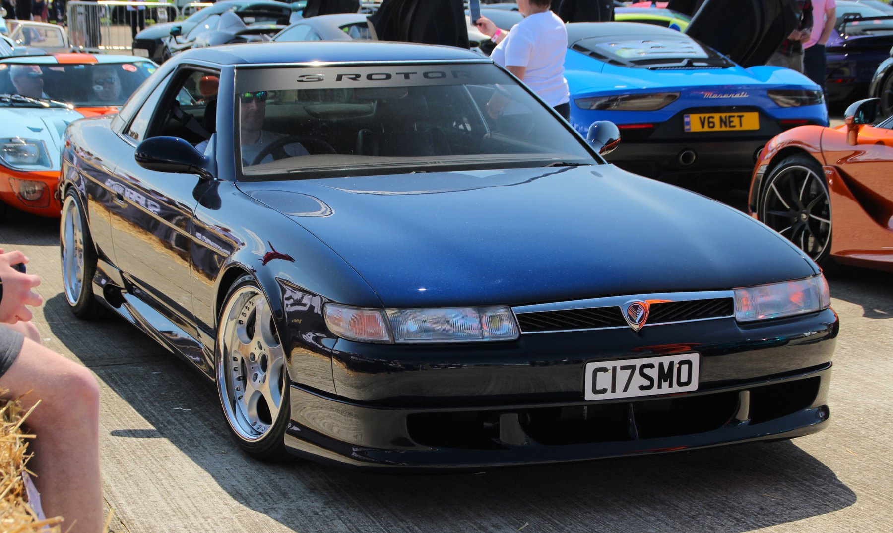 A 1991 car at Supercarfest in the UK, 2023, with a 3 ROTOR banner across the screen in case anyone missed it. Thirty-odd years on, the proportions still read as a car from a decade that hadn't happened yet.