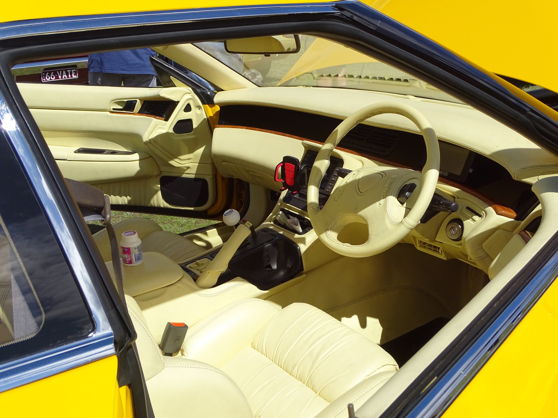 The cabin of a 20B car. Cream leather, wood trim, right-hand drive, and — visible on the console — the only transmission the Cosmo was ever sold with: a four-speed automatic.