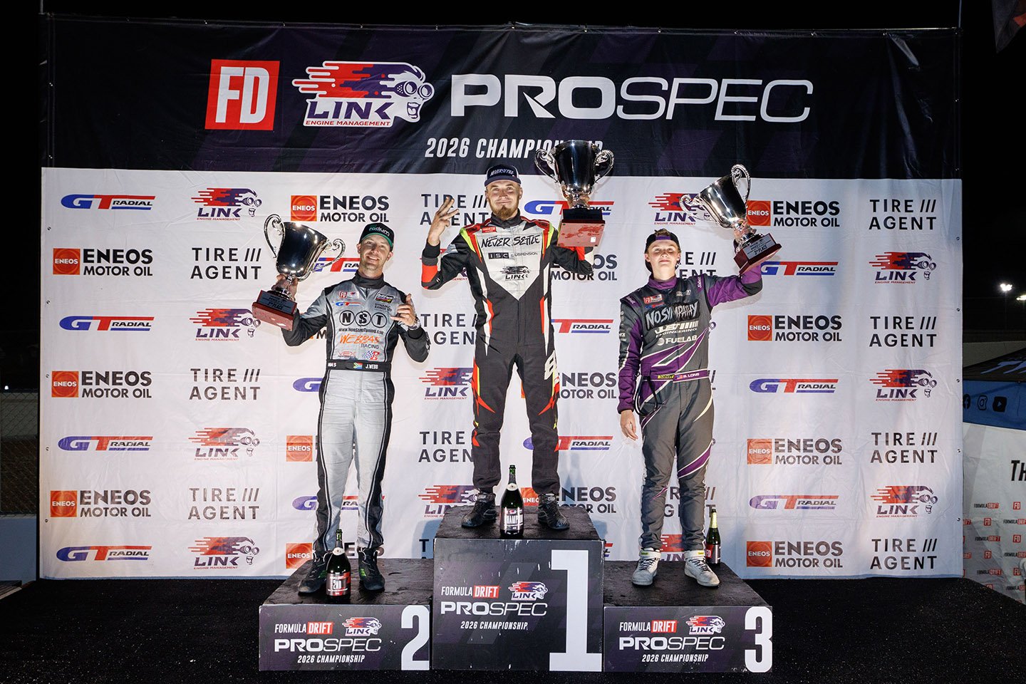 The PROSPEC finale podium at The Bullring: Jason Webb second, Dmitriy Brutskiy holding up three fingers for a third title, 16-year-old rookie Braden Lons third after winning the round.