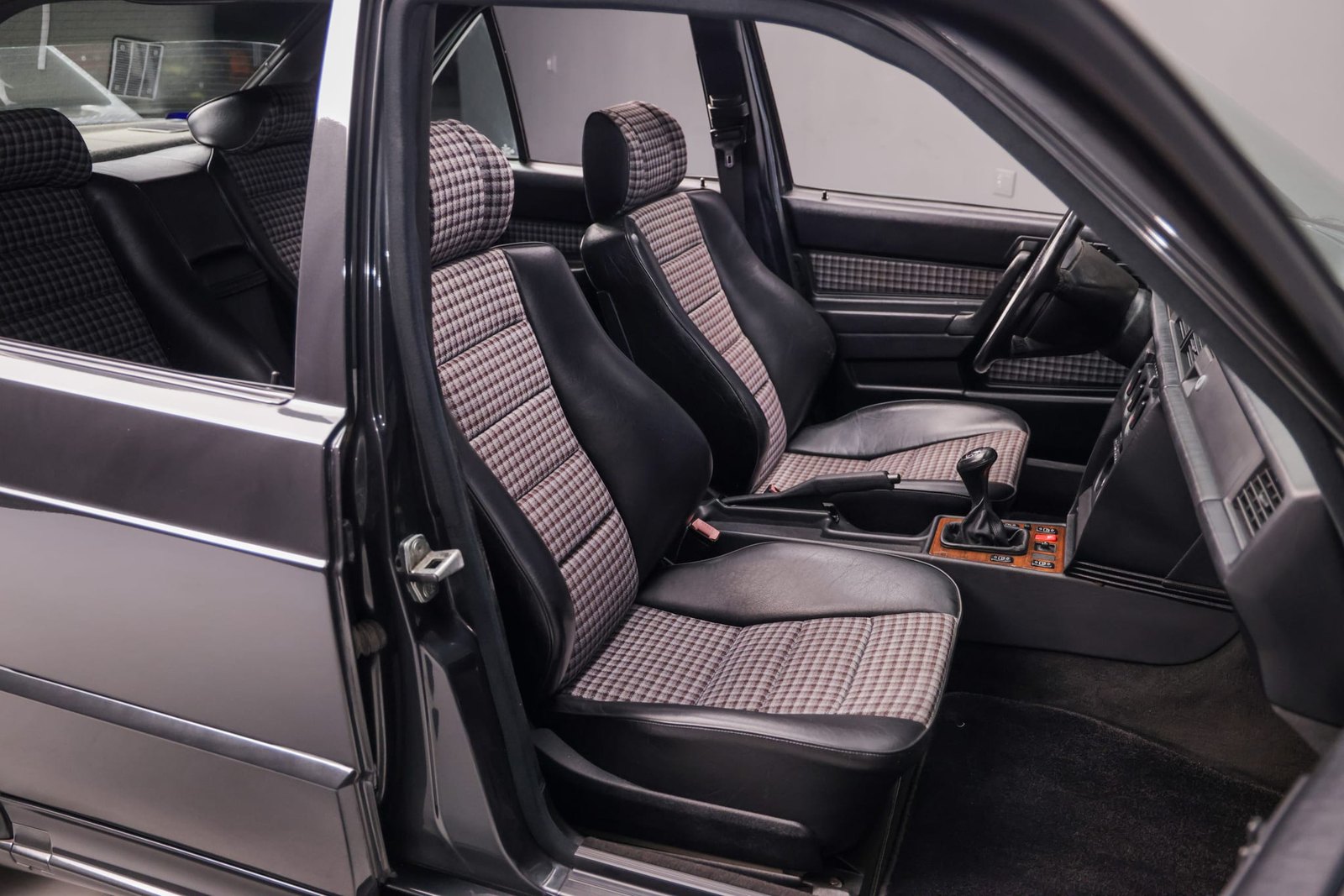 Black leather bolsters with the period houndstooth cloth centers — the Evolution II's standard upholstery, and one of the details buyers use to gauge a car's mileage claim.