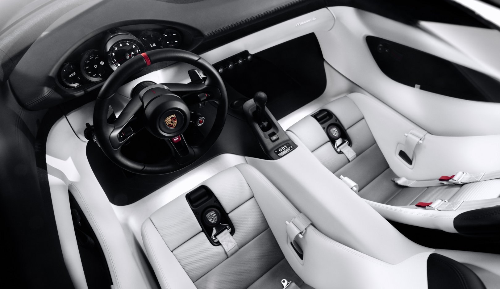 Five round instruments, an analogue needle on the rev counter, and no fixed centre screen anywhere in the cabin. The phone holder that replaces it retracts out of sight when it is not wanted.