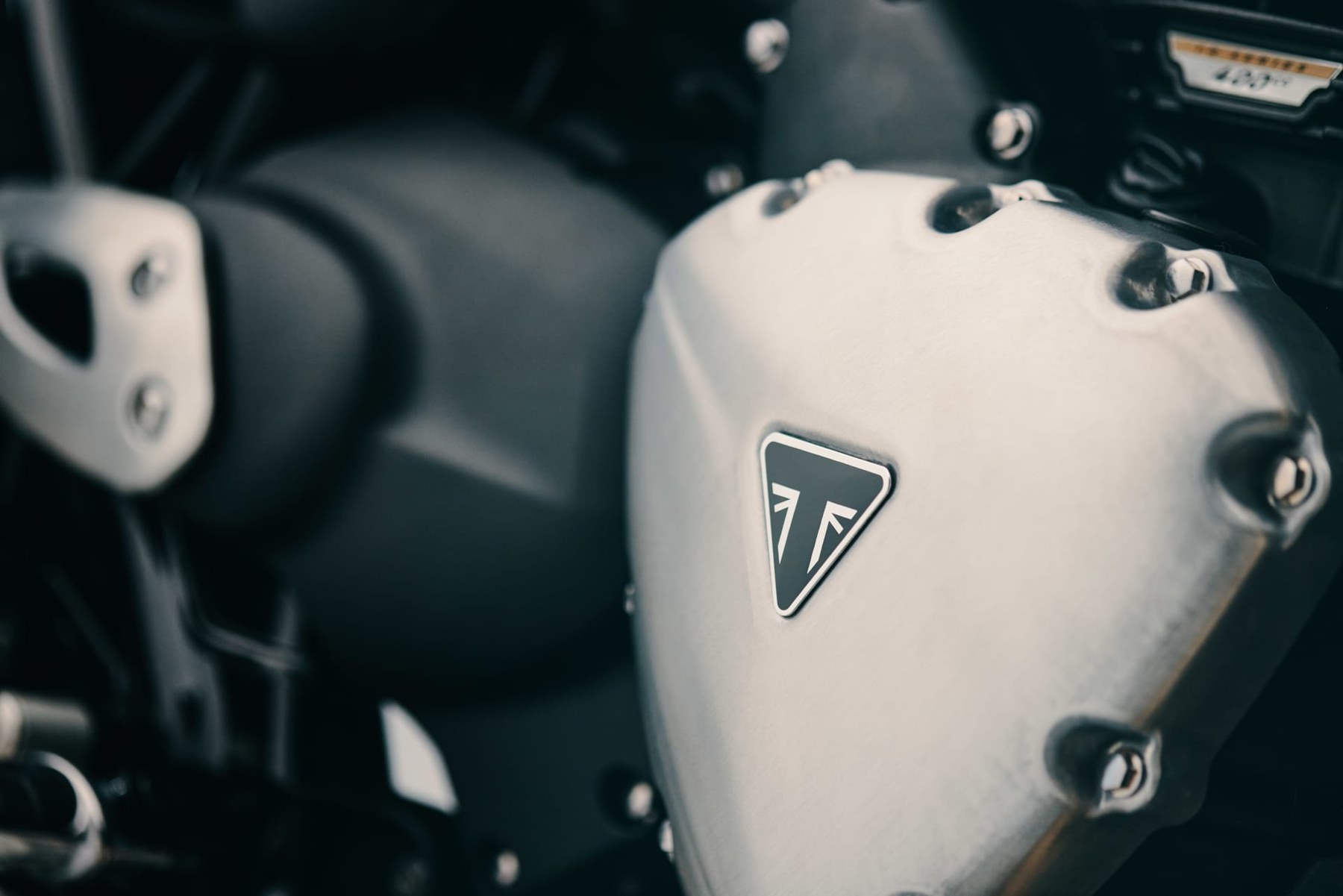 Classically shaped aluminium engine covers over a liquid-cooled, four-valve DOHC single. The finned barrel and the cover shapes are doing the work the twin used to do visually; underneath, this is the Bajaj-built architecture from the Speed 400 family.